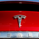 The rear of a Tesla car bearing the TESLA name and logo.